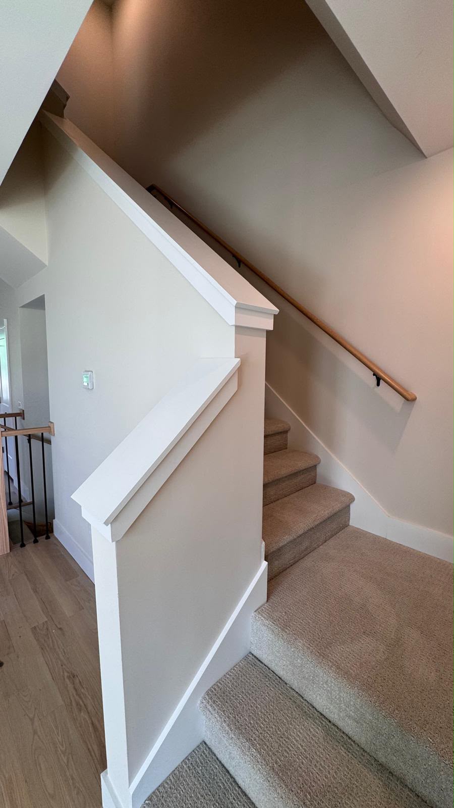 Finished staircase with painted walls, trim and handrail